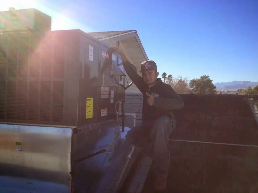 HVAC technician performing HVAC Inspection on a rooftop unit in Plainfield
